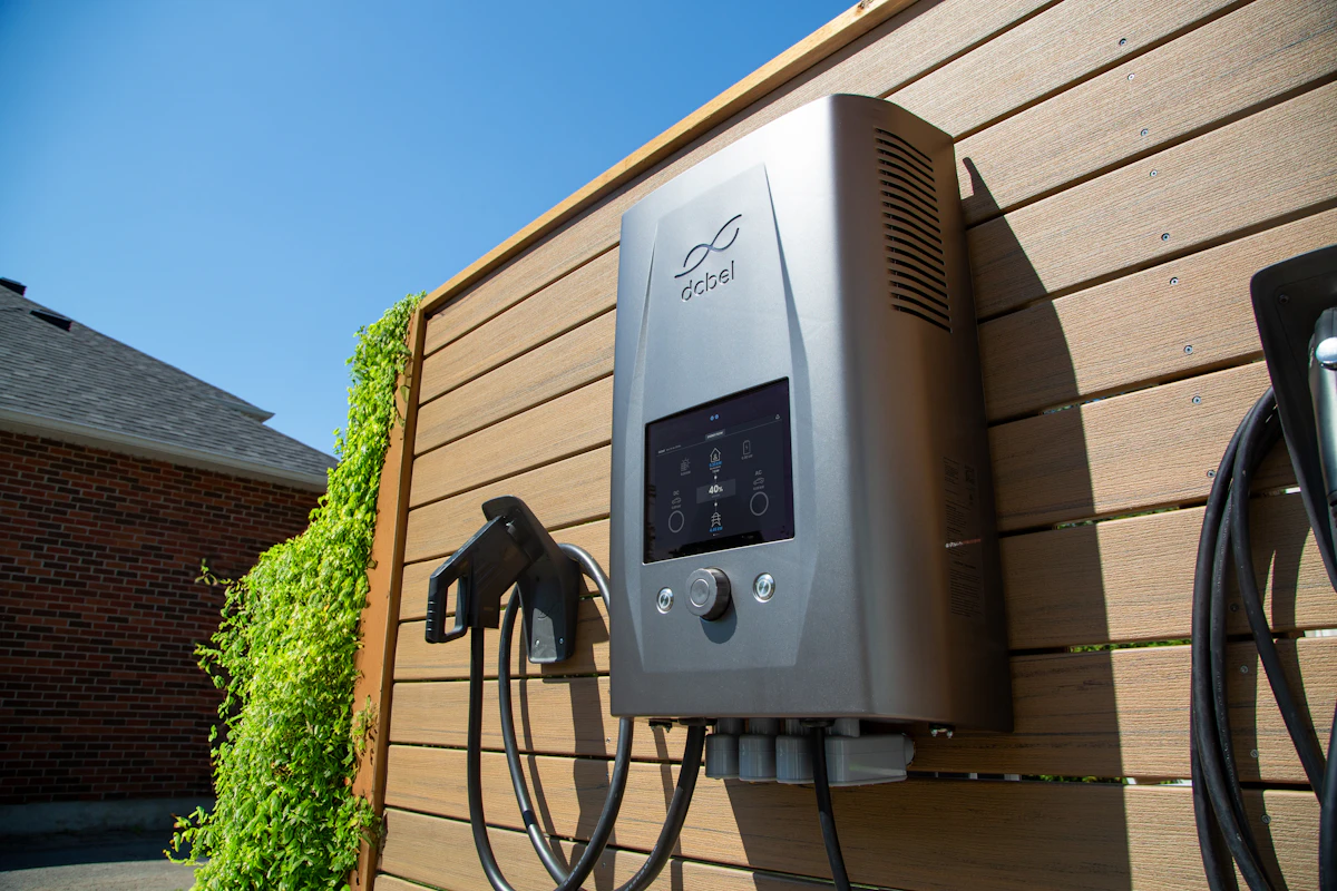 An electric car charger mounted on a wooden wall
